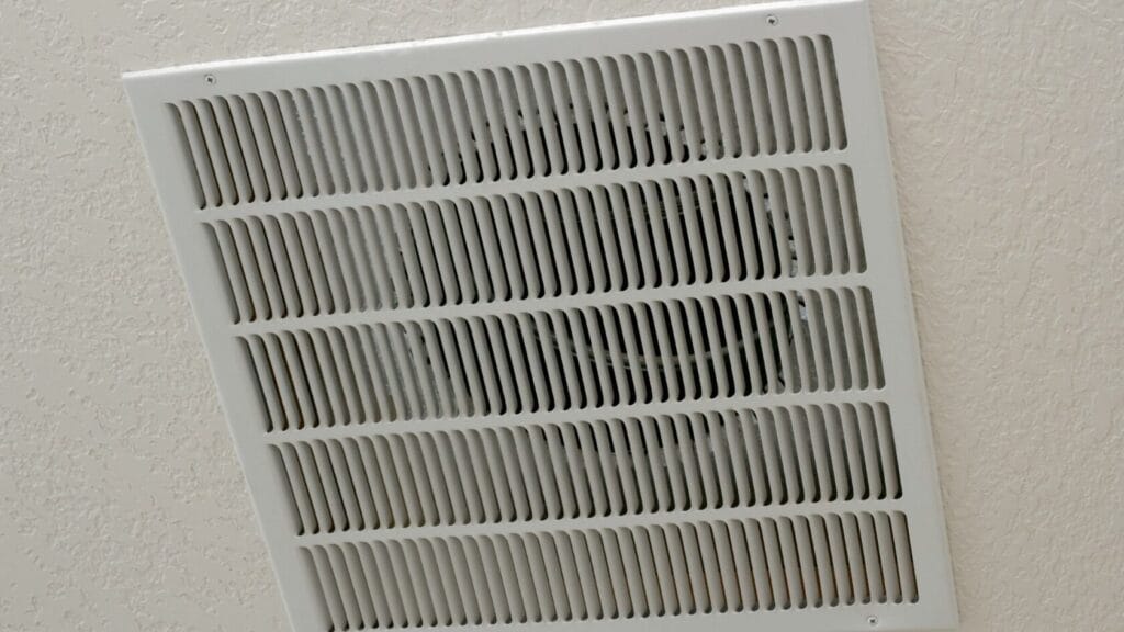 A white air vent installed on a ceiling, providing ventilation and air circulation in the bathroom.